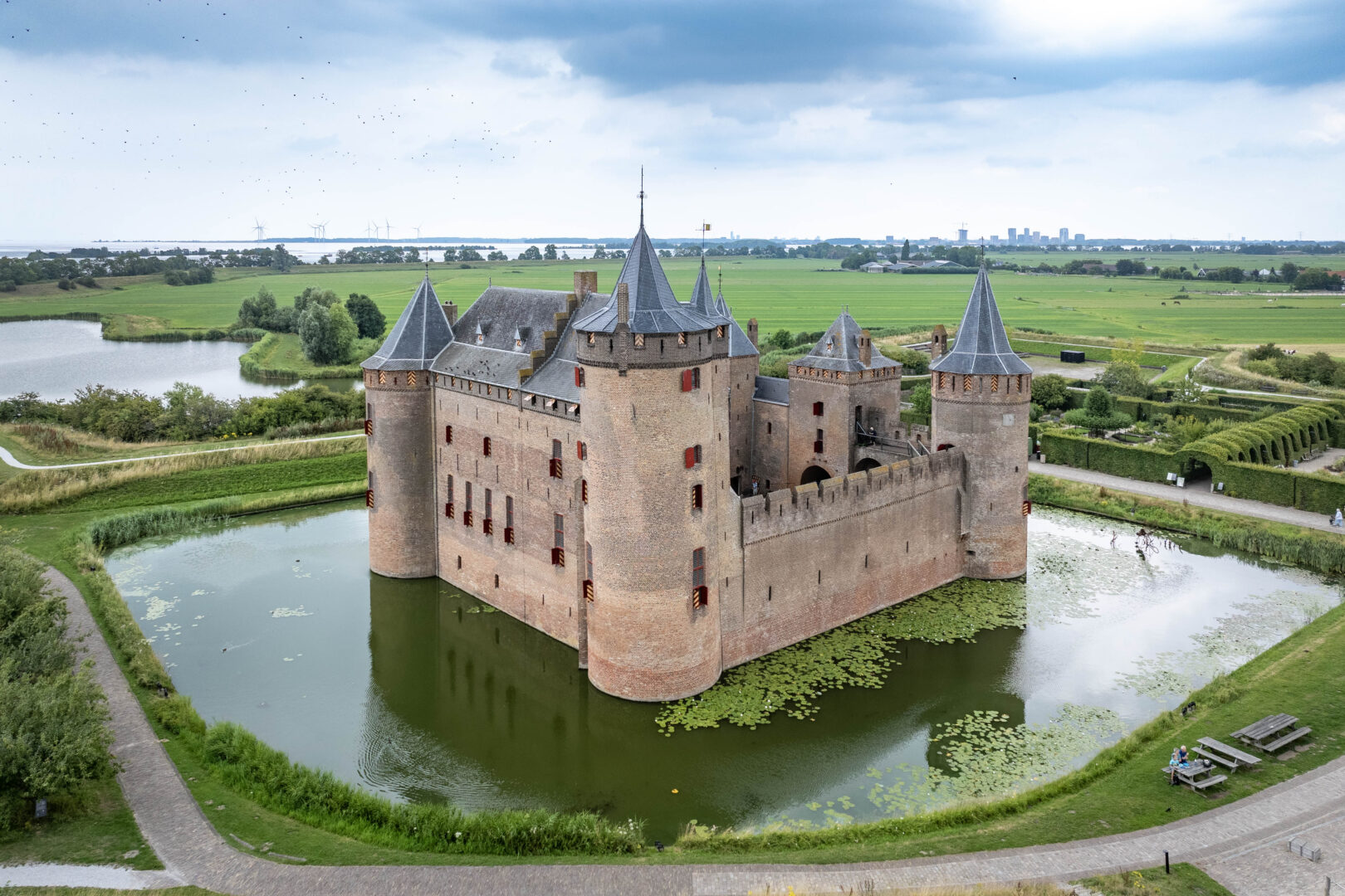 Het Muiderslot. Omringd door grachten, tuinen en uitgestrekt waterrijk landschap.