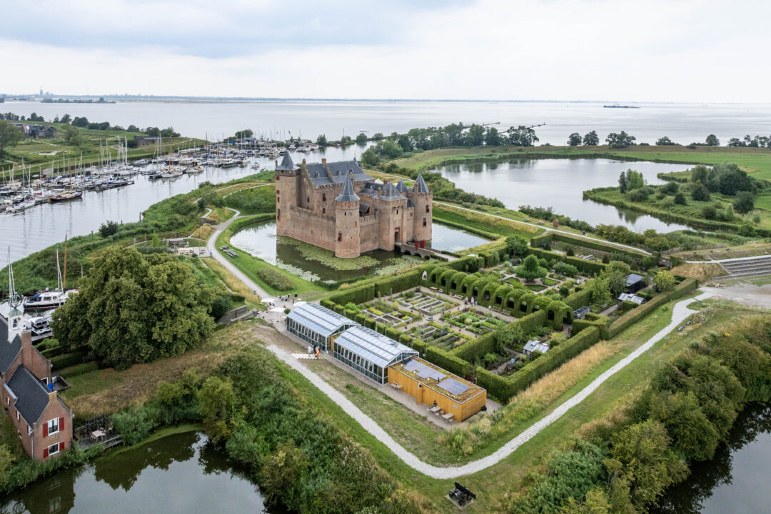 Het Muiderslot. Omringd door grachten, tuinen en uitgestrekt waterrijk landschap.