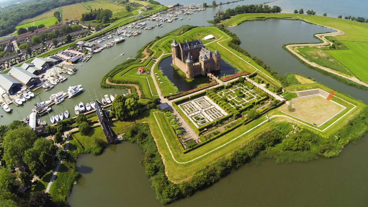 Luchtfoto van het Muiderslot omgeven door water.