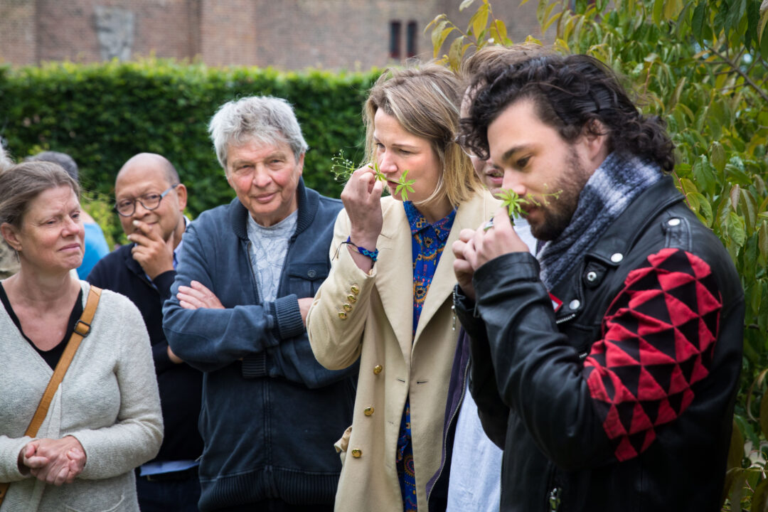 Siebren Houwer, kasteelkok van het Muiderslot, ruikt aan een bloem in de tuin.