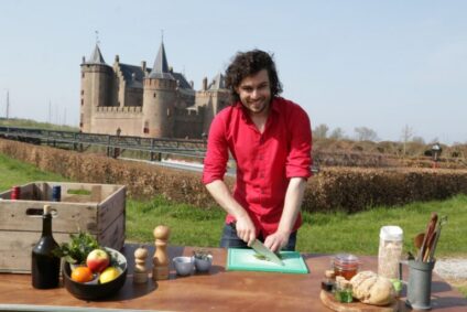 De kasteelkok van het Muiderslot, is buiten aan het koken op het Muiderslot. De zon schijnt.