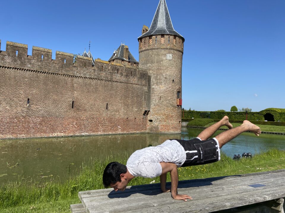 Man in yoga position with the Muiderslot in the background