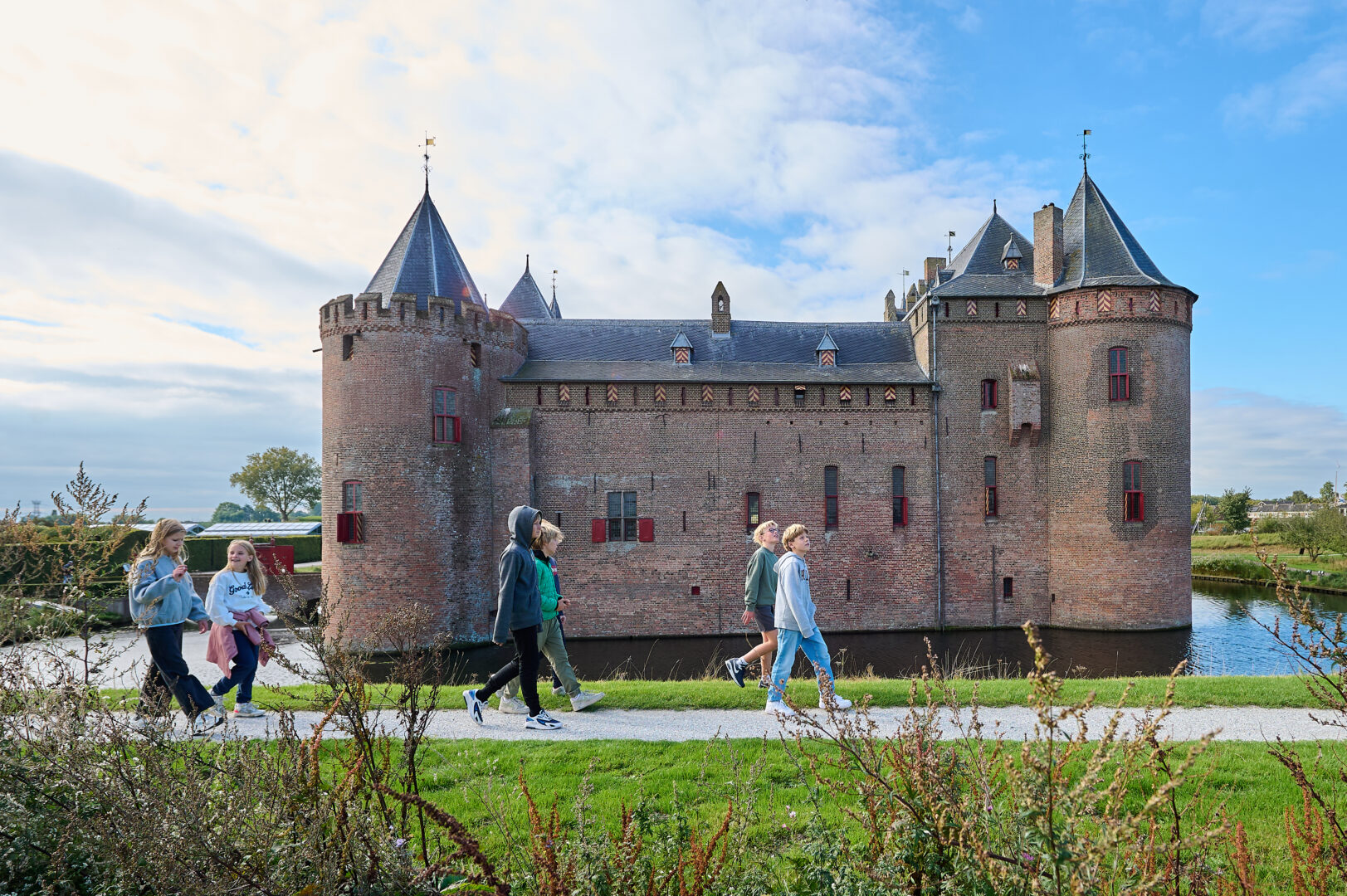 Leerlingen wandelen in kleine groepjes om het kasteel.