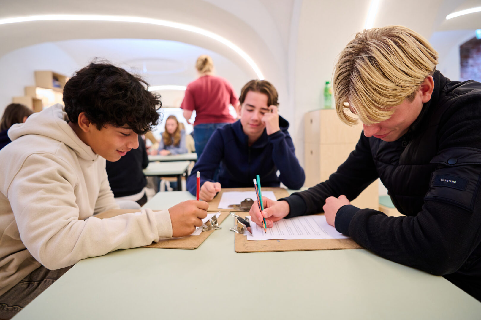 Drie jongens zijn samen aan het werk.