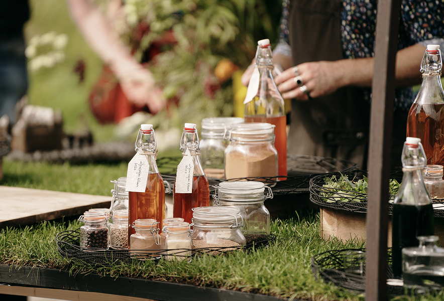 Pruimenlikeur en kruiden in glazen potten met een labeltje er aan tijdens het Pruimenweekend bij het Muiderslot.