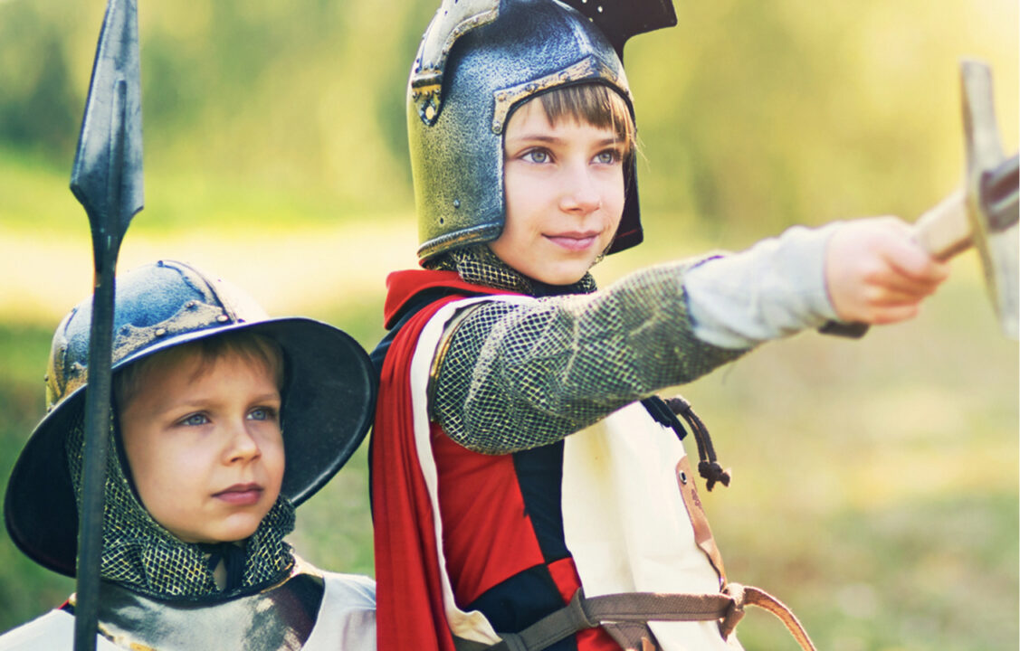 Two young children dressed up as knights.