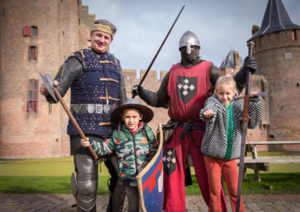 Twee volwassenen en twee kinderen als middeleeuwse ridders verkleed.