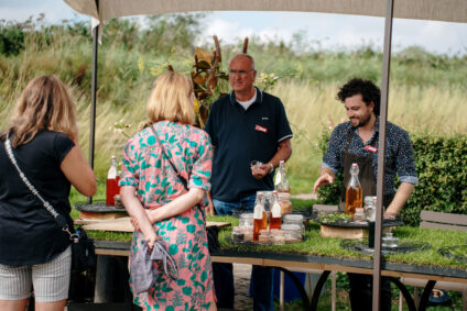 Siebren Houwer, de kasteelkok van het Muiderslot, verkoopt siroop op een markt tijdens het pruimenweekend.