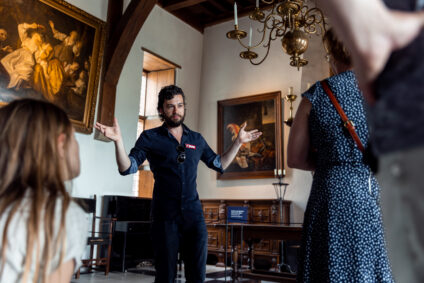 Siebren Houwer, kasteelkok van het Muiderslot, leidt een groep mensen rond tijdens een tasting in het muiderslot. Ze staan in de Ridderzaal.