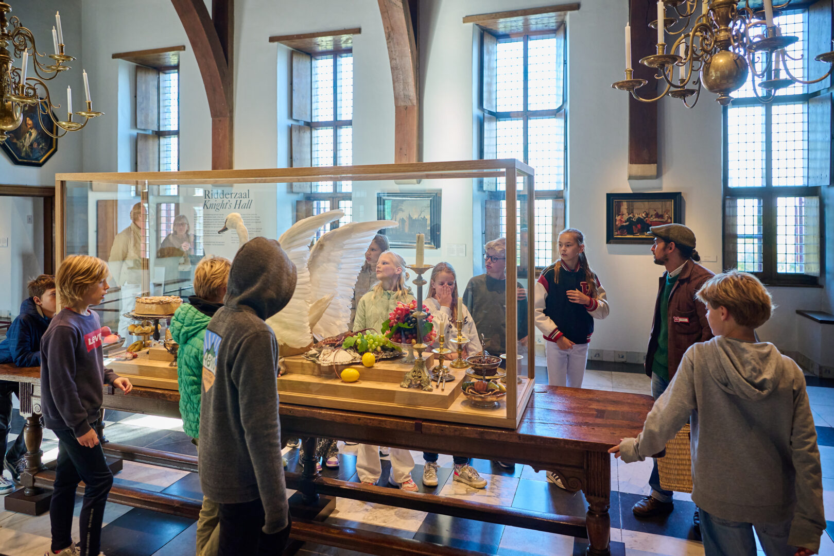 Kinderen kijken naar een presentatie op zaal in het Muiderslot tijdens een schoolbezoek.