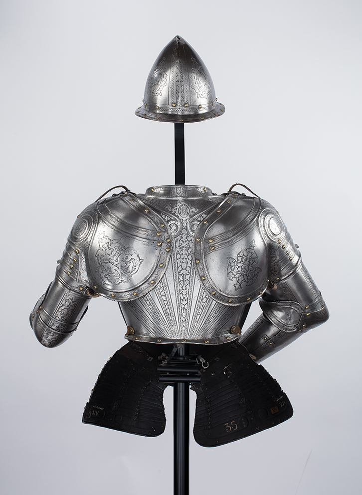 De achterkant van een historisch pronkharnas bestaande uit verschillende onderdelen.