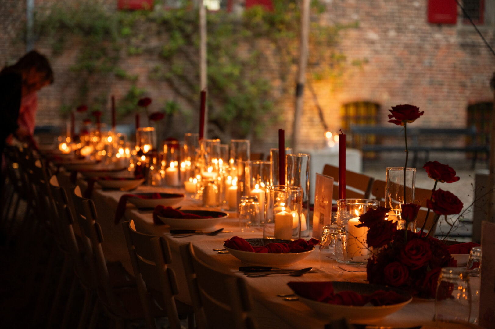 Gedekte lange tafel met kaarsjes op de binnenplaats van het kasteel.