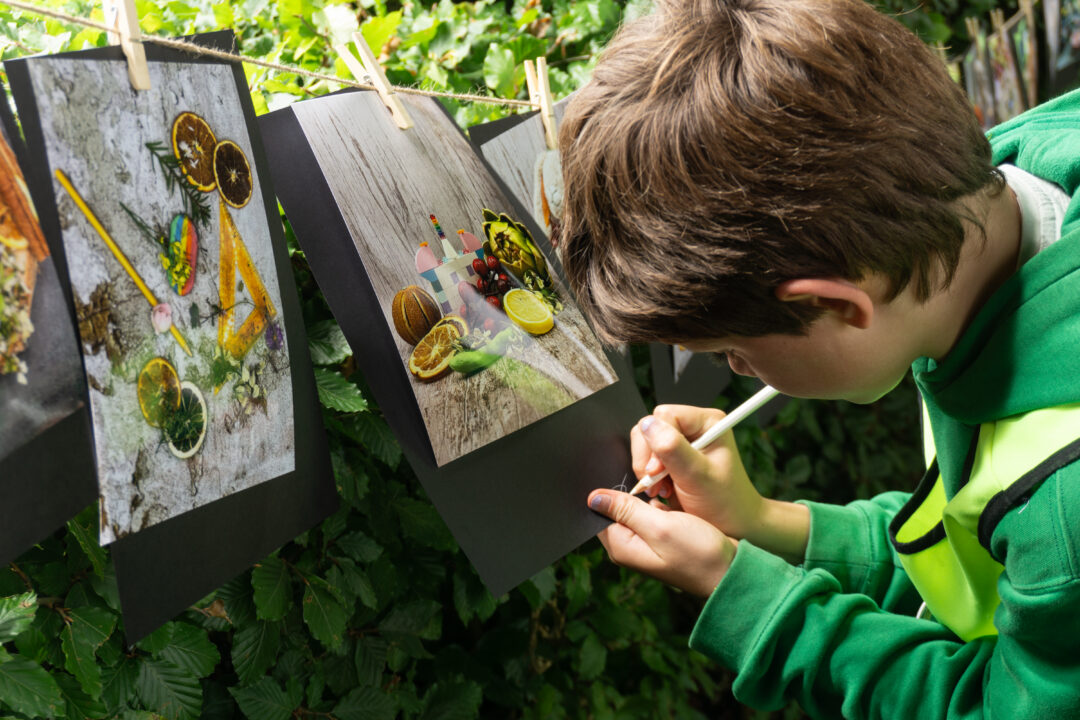kind maakt kunst in tuin