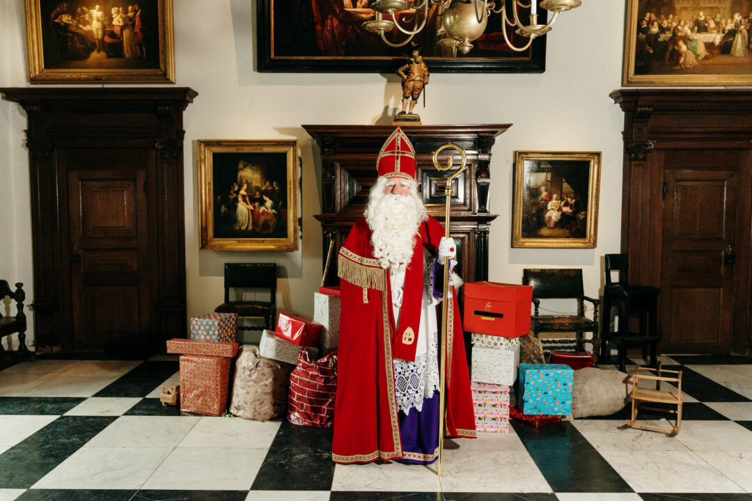 Sinterklaas in de ridderzaal met pakjes om hem heen