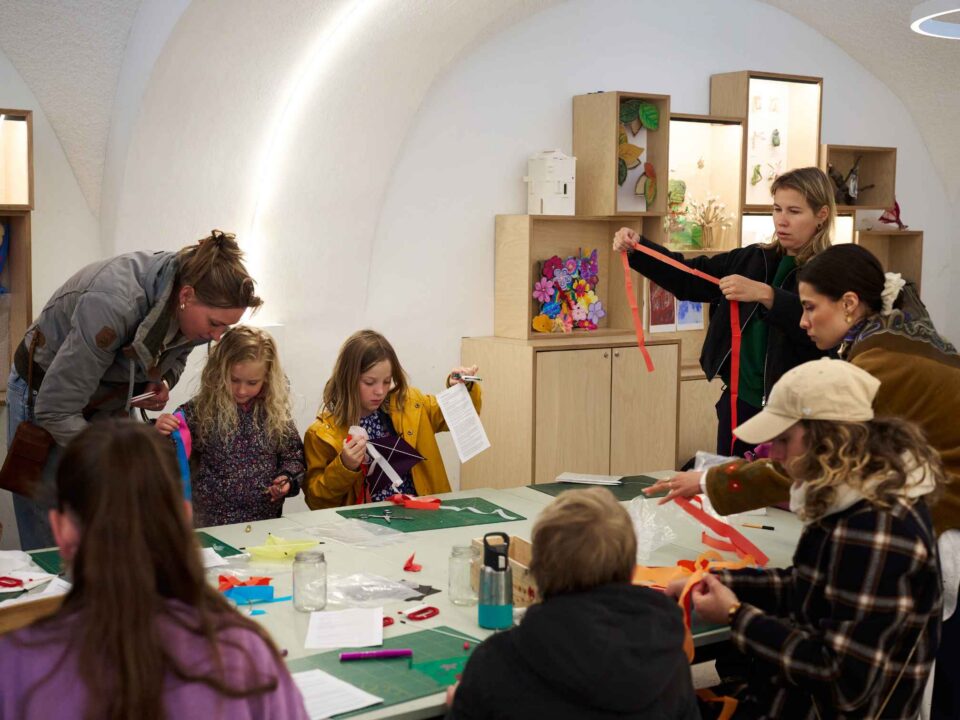 ouders en kinderen actief aan het werk in atelier