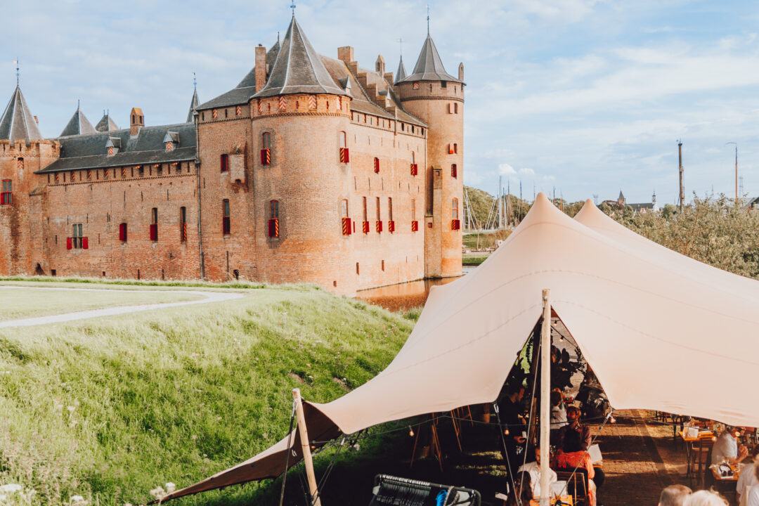 Feesttent op de voorgrond met op de achter grond Muiderslot