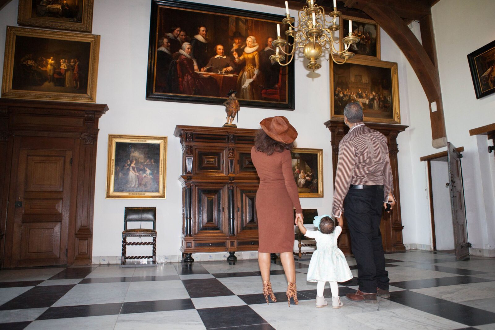 gezin kijkt naar schilderijen in de ridderzaal van het muiderslot